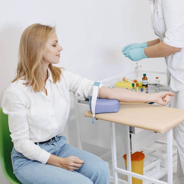 Profesional de salud preparando una toma de sangre con una paciente